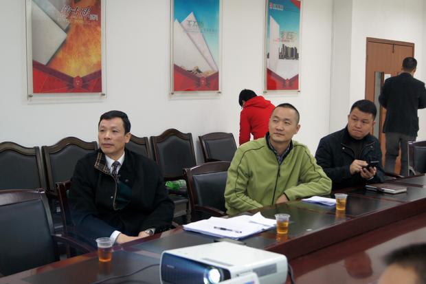 图6、寓目幻灯片的同时，918博天堂仿古砖副总曹坚贞（右一）特殊用手机记下专卖店装修效果的差别亮点